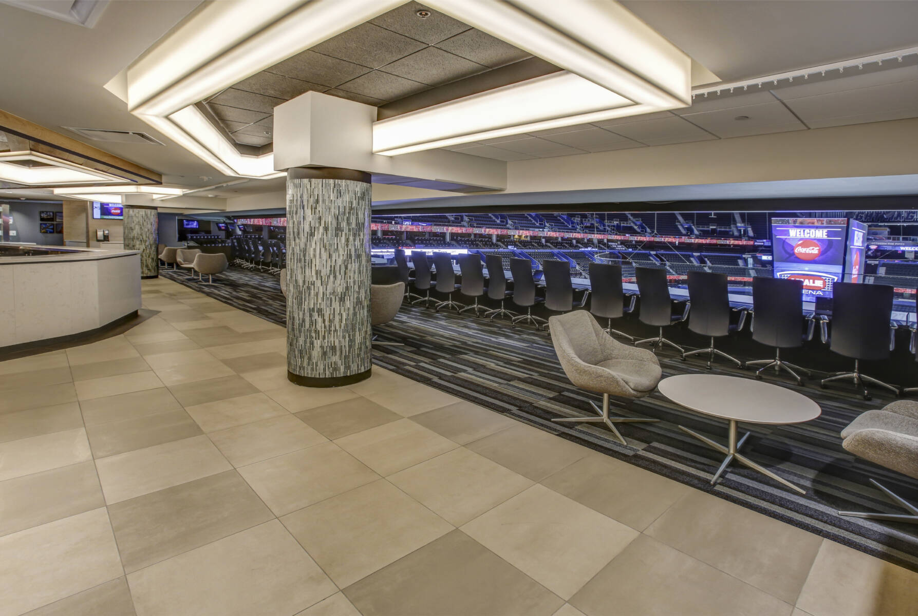 A cream-tiled corridor framing the carpeted stadium seating at Amalie Arena. This image demonstrates this company's excellence in multi-purpose sports flooring