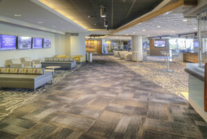 Communal room with neutral carpet tile. This image demonstrates this company's excellence in multi-purpose sports flooring installations.