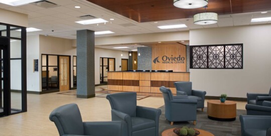 Medical center lobby with blue shares and check-in counter in background.