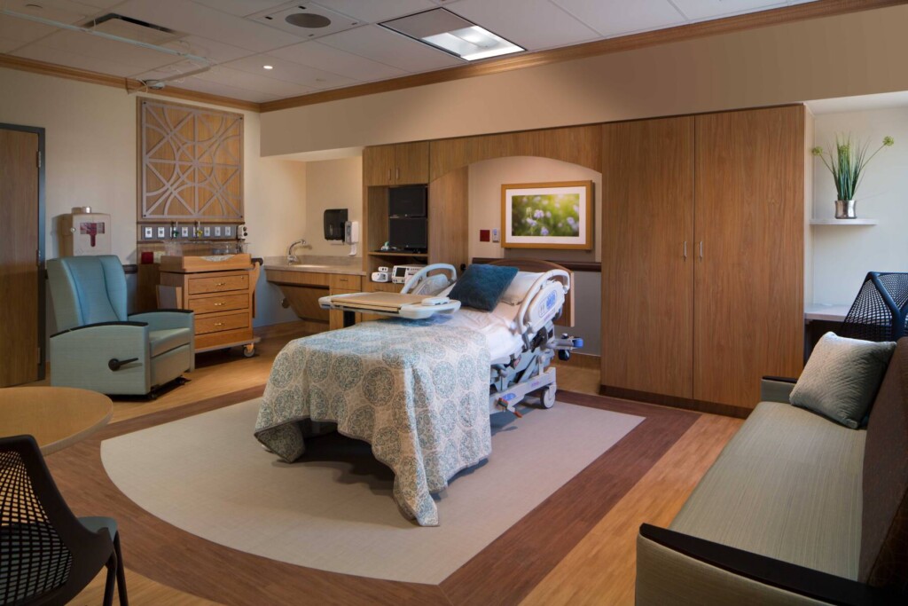 Patient room with bed and patterned flooring beneath.