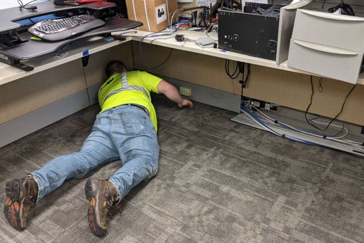 Laborer working on carpet tile in a corporate cubicle to demonstrate Diverzify's expertise in occupied installs.